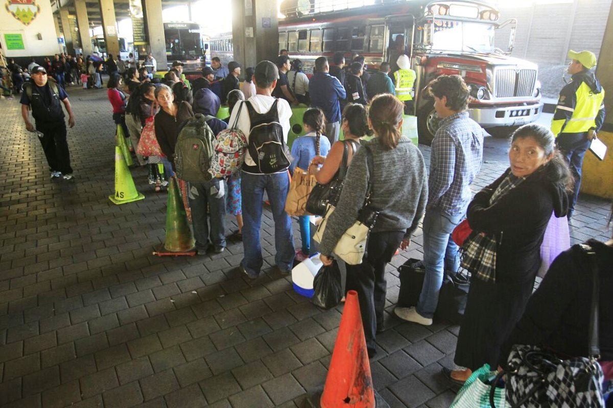Personas abordan buses que los llevan a los departamentos. (Foto Prensa Libre: Carlos Hernández)