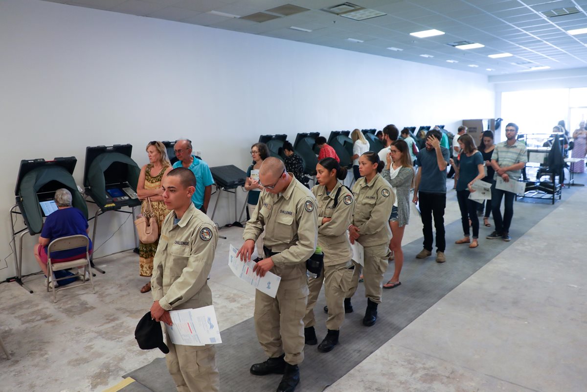 Jóvenes hacen fila durante la jornada de votación anticipada para las elecciones 2018 en Huntington Beach, California. (Foto Prensa Libre: EFE)