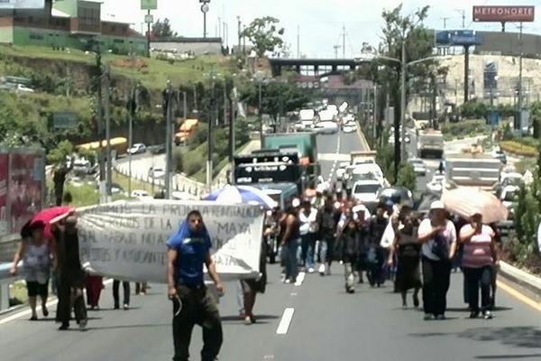 Pilotos y ayudantes caminaron desde el kilómetro 13 de la ruta al Atlántico hacia el puente Belice para protestar. (Foto Prensa Libre: Erick Ávila)