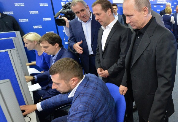 Vladimir Putin (d) y Dimitri Medvédev (2d) visitar la sede de la campaña electoral.(Foto Prensa Libre: AFP)