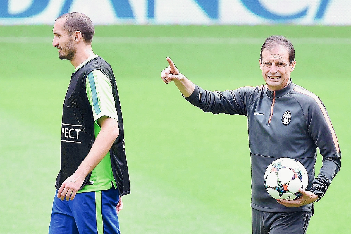 El entrenador de la Juventus, Massimiliano Allegri junto al jugador Giorgio Chiellini durante el entrenamiento del pasado lunes. (Foto Prensa Libre: EFE)