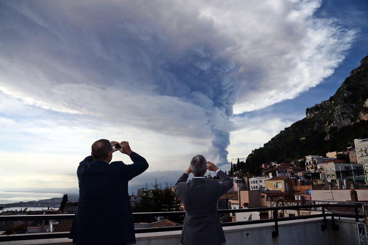 Curiosos fotografían la actividad eruptiva del volcán Etna. (Foto Prensa Libre: AFP).