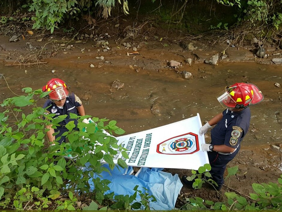 Socorristas resguardan el cuerpo que fue localizado en la orilla de un río. (Foto Prensa Libre: BMD)