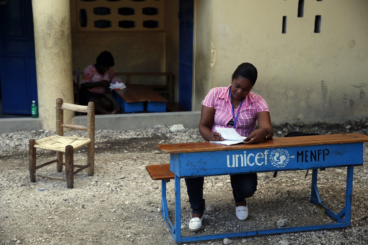 Una fiscal espera la apertura de un centro en el colegio República de Guatemala, en Haití. (Foto Prensa Libre: EFE)