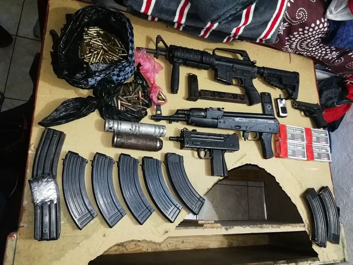 Fusiles, pistolas, chaleco antibalas, municiones de diferentes calibres y dos kilos de cocaína es lo decomisado a Gamez Reyes alias "el pulga" del barrio 18. (Foto Prensa Libre: Cortesía PNC)