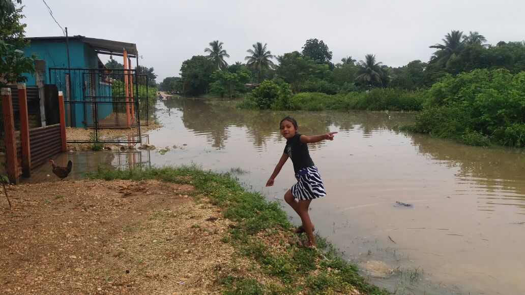 Una niña juega frente a lo que aparente ser un río, pero es una calle inundada. (Foto Prensa Libre: Rigoberto Escobar)