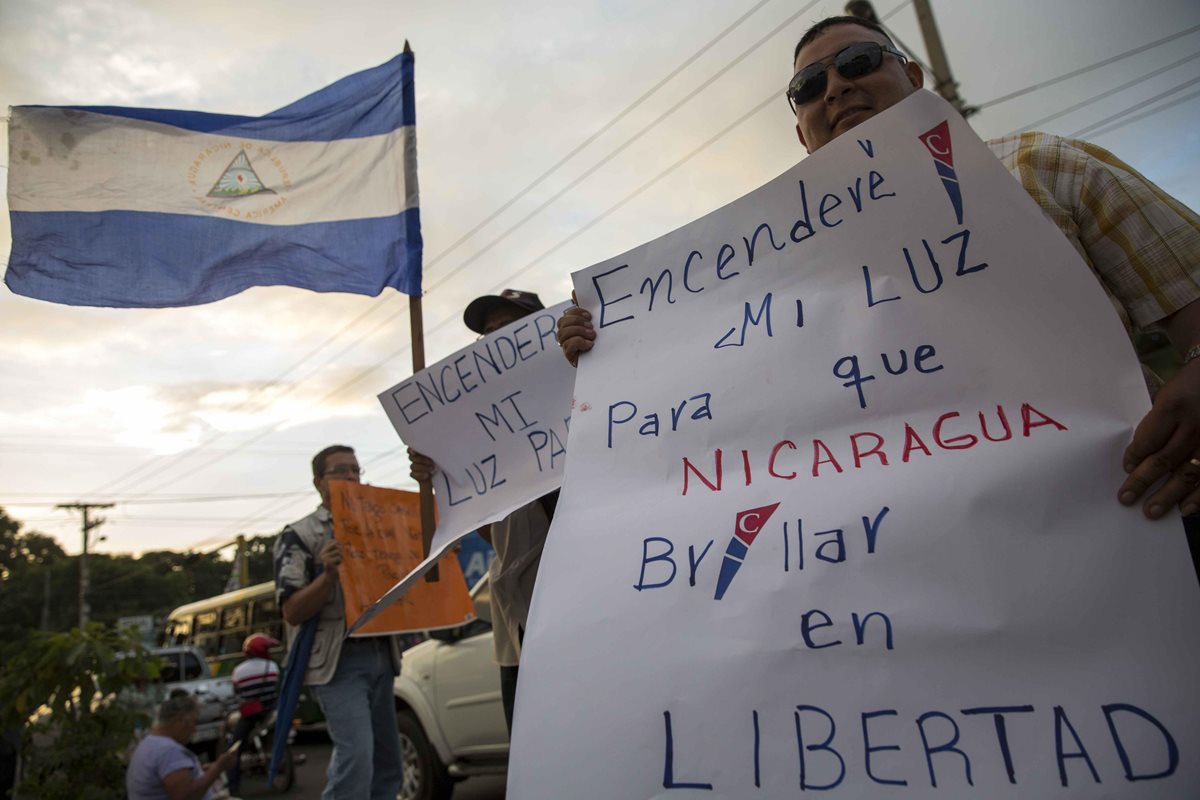 Un hombre sostiene una pancarta mientras participa en una protesta en demanda de elecciones libres y transparente en Nicaragua. (Foto Prensa Libre: EFE).
