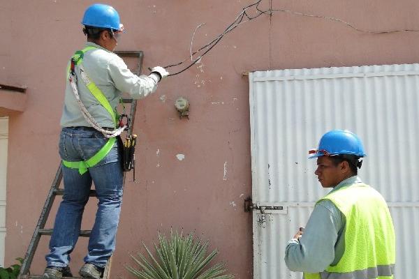 Técnicos de Energuate revisan la conexión eléctrica  en una casa del área urbana de Estanzuela.