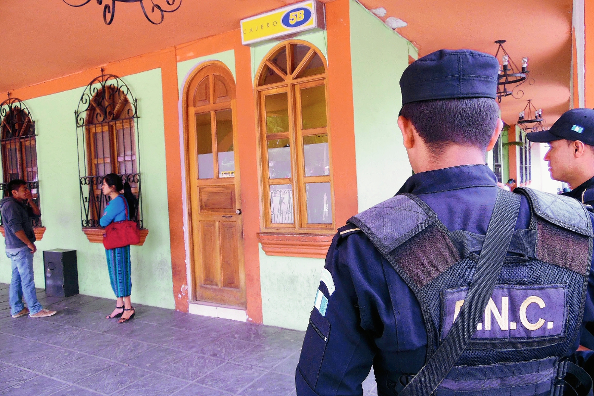 Agentes de la PNC prestan seguridad a cuentahabientes. (Foto Prensa Libre: José Rosales)