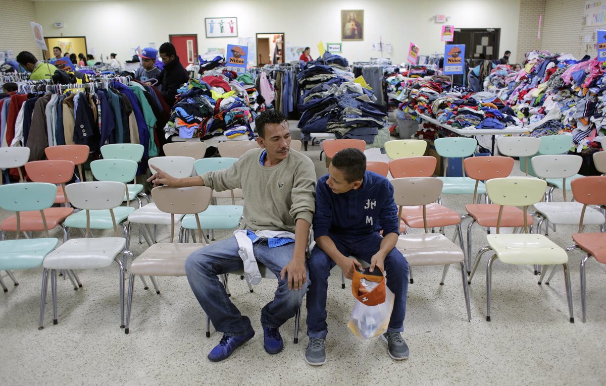 Los migrantes hondureños Roger Mesa (der.) y su padre Luis Carlos, permanecenen el Centro Comunitario Sagrado Corazón en la ciudad fronteriza de McAllen, Texas, EE. UU. (Foto Prensa Libre: AP).