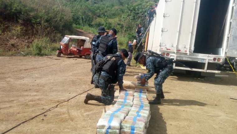 Agentes antinarcóticos examinan y contabilizan los paquetes hallados en un furgón, interceptado en Zacapa. (Foto Prensa Libre: PNC)