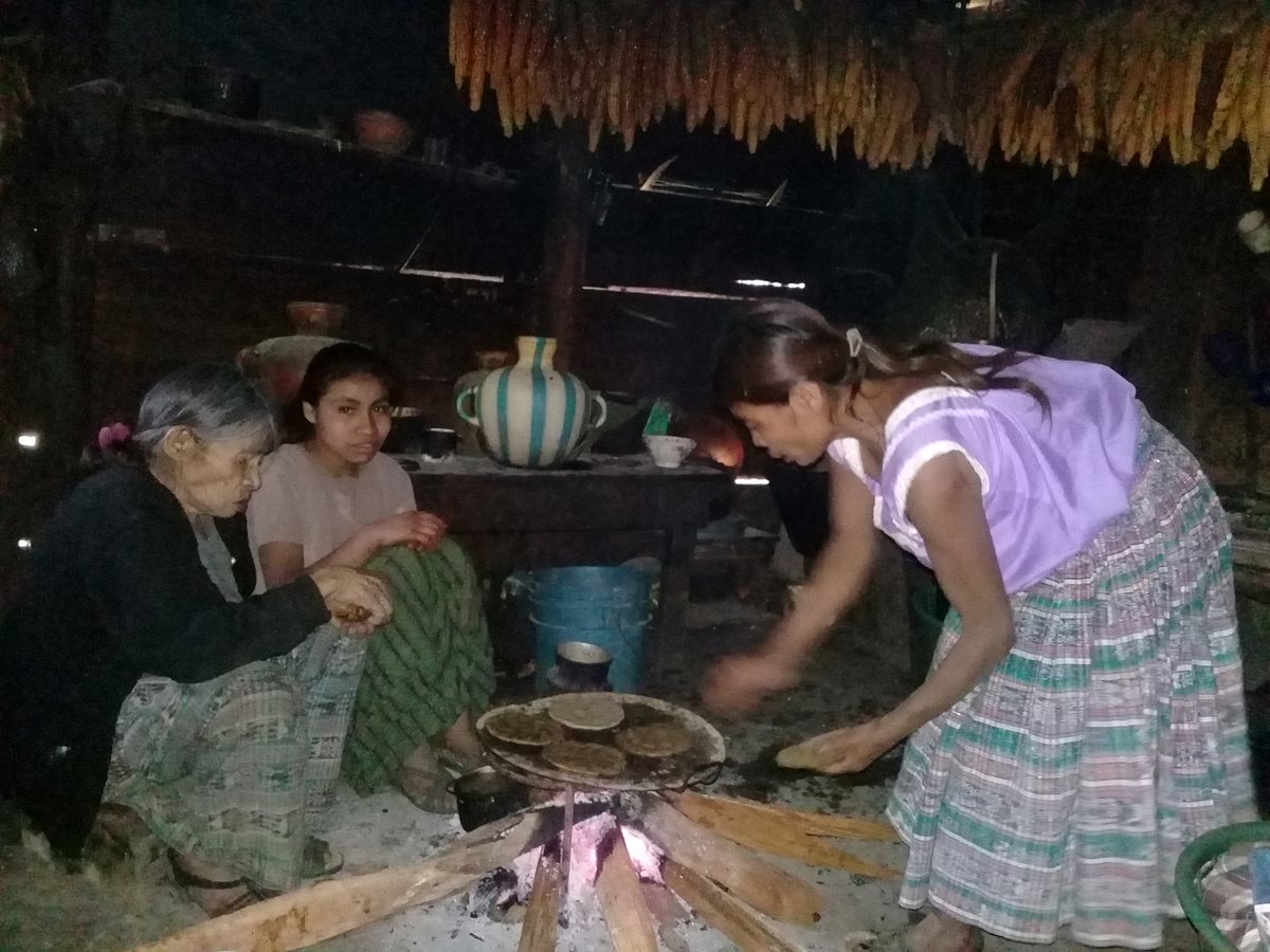Santos Si Xol comparte alimentos junto a su hija y nietas en San Juan Chamelco. (Foto Prensa Libre: Eduardo Sam).