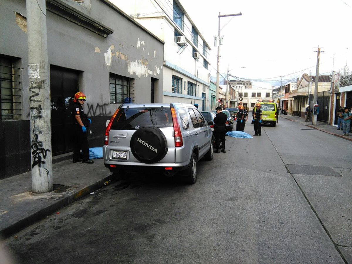Entre los vehículos que cuidaban quedaron los cadáveres de dos hombres en la 11 avenida y 15 calle, zona 1. (Foto Prensa Libre: Estuardo Paredes)