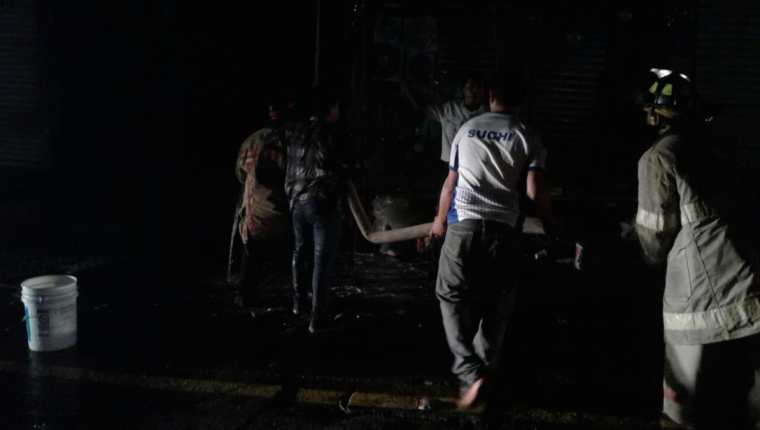 Vecinos y socorristas trabajan para apagar las llamas que se encentran en el alcantarillado. (Foto Prensa Libre: Melvin Popá)