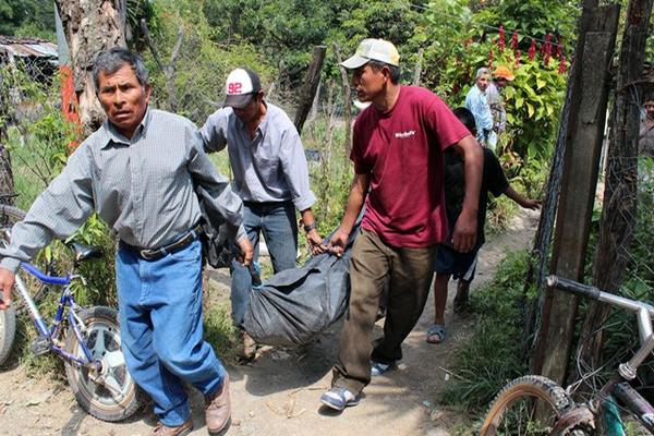 Vecinos trasladan a la morgue el cadáver de Nazario González Nájera. (Foto Prensa Libre: Hugo Oliva)