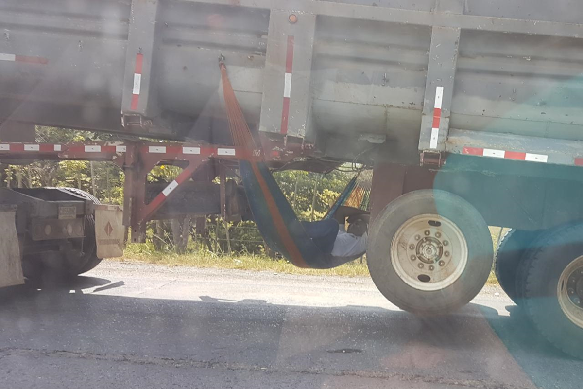 Un trailero descansa en una hamaca debajo del furgón que transportaba. (Foto Prensa Libre: Dony Stewart)