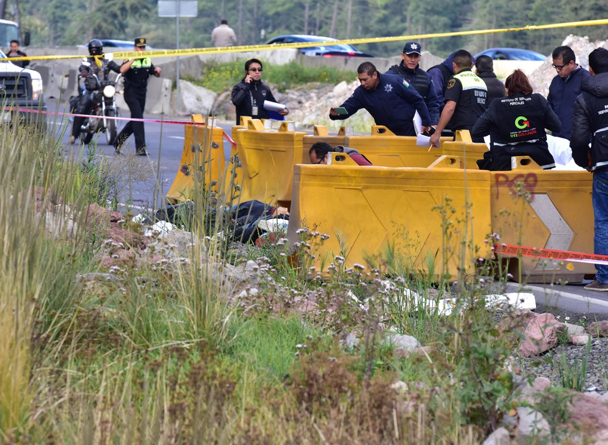 Autoridades mexicanas trabajan en el sitio donde encontraron los cuerpos de cuatro personas que presuntamente fueron atacadas a balazos por el pasajero. (Foto Prensa Libre: EFE).