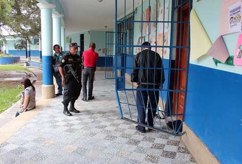 Agentes de la Policía inspeccionan una de las puertas forzadas en la escuela de Jalapa. (Foto Prensa Libre: Hugo Oliva)