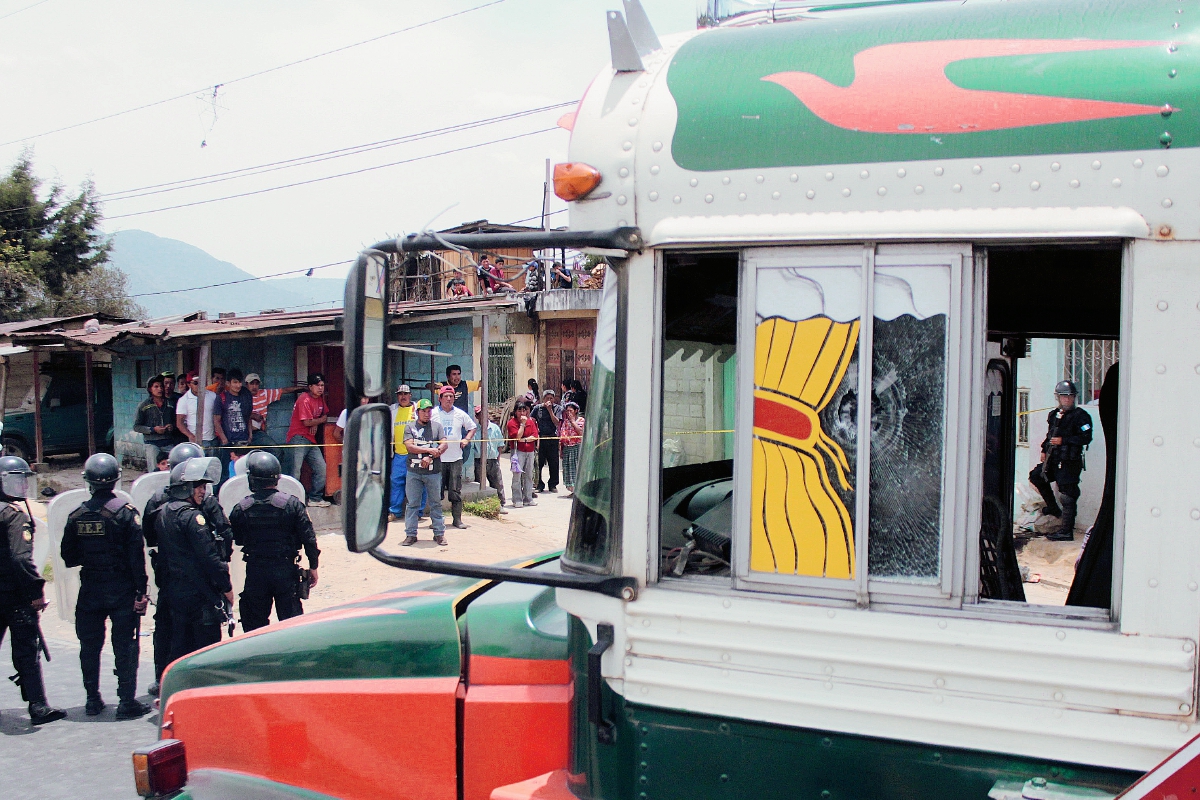 Agentes de  la PNC acordonan área donde fue atacado el piloto de un autobús, en Concepción Chiquirichapa, Quetzaltenango. (Foto Prensa Libre: Carlos Ventura)