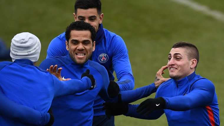 Dani Alves junto bromea con sus compañeros del PSG en el entrenamiento previo al partido de vuelta entre el PSG y el Real Madrid. (Foto Prensa Libre: AFP)