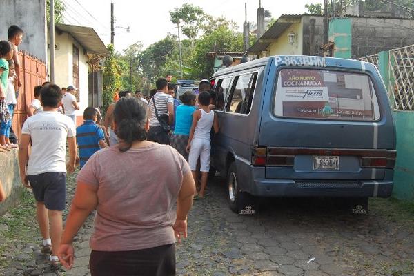 Vecinos del cantón Los Encuentros observan el microbús en donde fue herido su piloto, Alberto Baltazar. (Foto Prensa Libre: Alexander Coyoy)