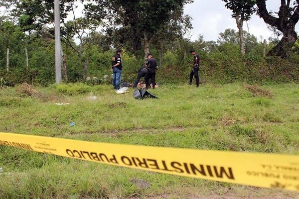 Fiscales del Ministerio Público y agentes de la Policía observan la escena del doble crímen. (Foto Prensa Libre: Hugo Oliva)<br _mce_bogus="1"/>