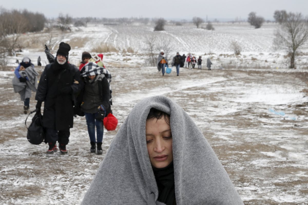 Inmigrantes cruzan campos helados a través de la frontera con Macedonia en Serbia. (Foto Prensa Libre: EFE)