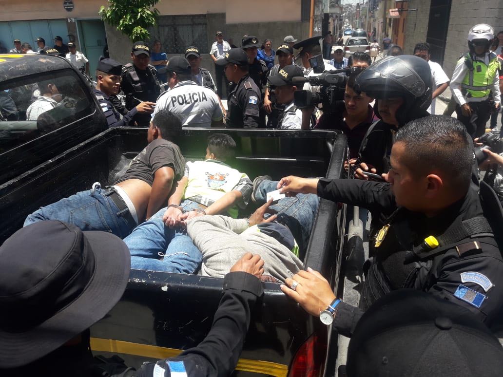 Momento en que la PNC conduce a los tres detenidos hacia el Juzgado de Turno. (Foto Prensa Libre: Cortesía)