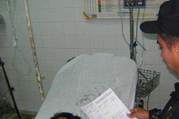 Agente de la PNC verifica los datos de Adolfo Coronado, quien permanece en el Hospital Nacional de San Marcos, luego de que una turba lo vapuleara. (Foto Prensa Libre: Aroldo Marroquín)