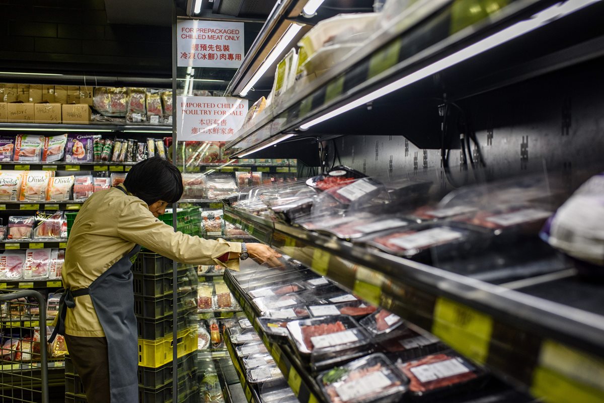 Un empleado de un supermercado en Hong Kong retira productos de estantes, luego del escándalo sobre carne posiblemente contaminada procedente de Brasil. (Foto AFP)