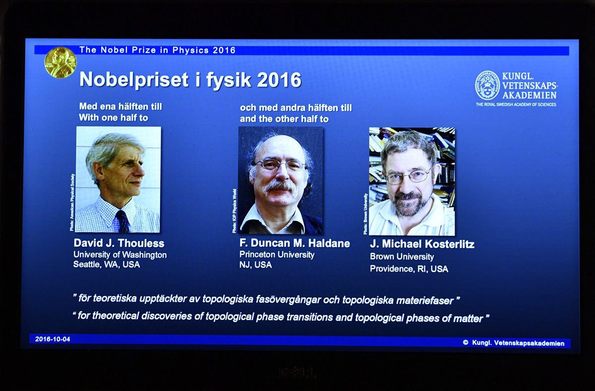 Imagen de una pantalla en la Academia de Ciencias de Estocolmo, Suecia, que muestra a los científicos británicos David Thouless, Duncan Haldane y Michael Kosterlitz. (Foto Prensa Libre: EFE)