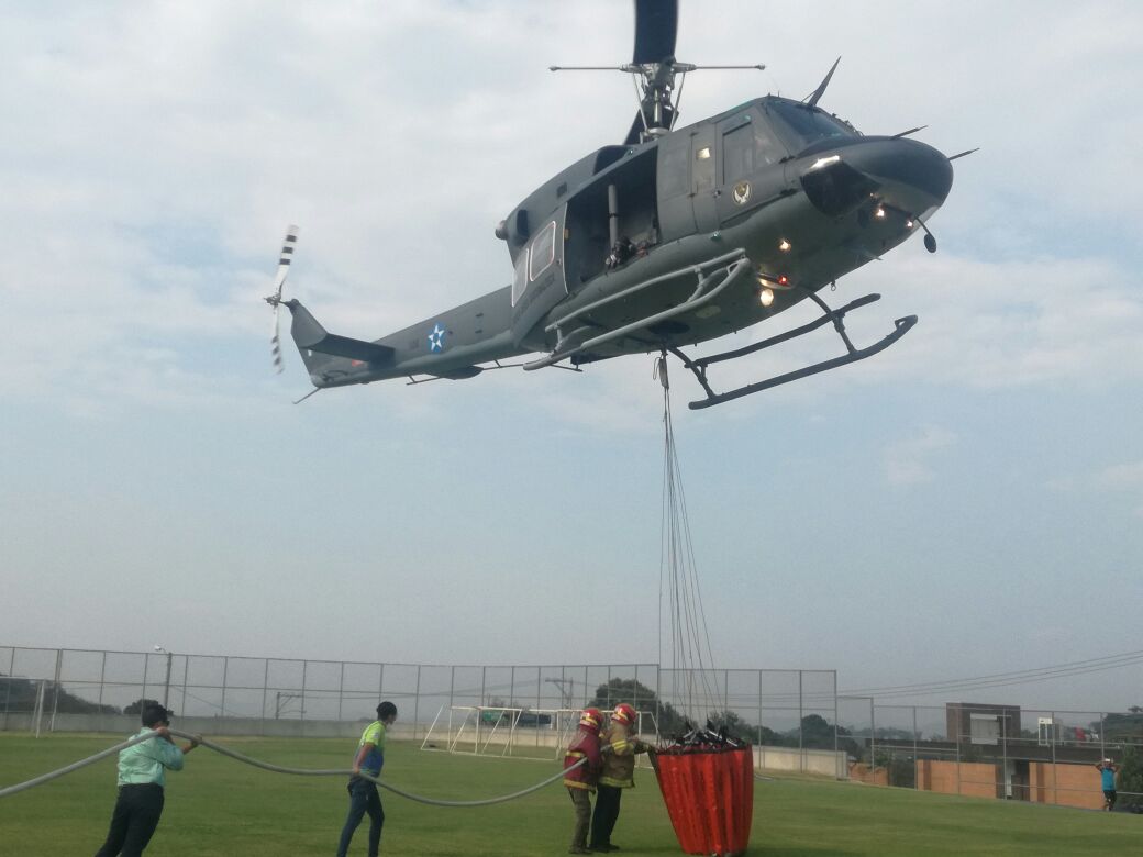 Voluntarios ayudan a cargar agua al helicóptero en el colegio Agustiniano. (Foto Prensa Libre: Cortesía Muni de Mixco)