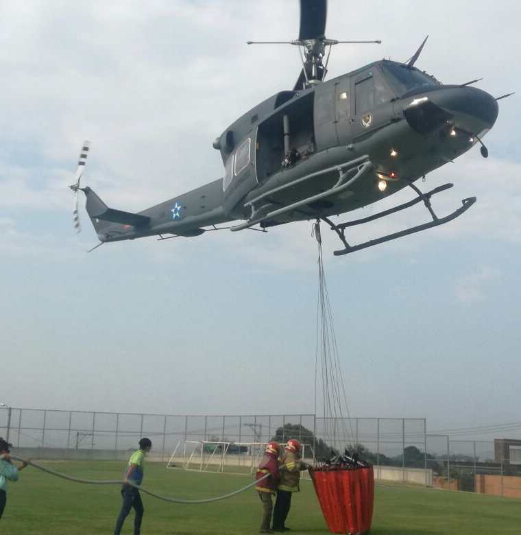 Voluntarios ayudan a cargar agua al helicóptero en el colegio Agustiniano. (Foto Prensa Libre: Cortesía Muni de Mixco)