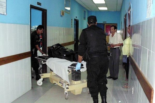 Agentes de la Policía Nacional Civil ingresan el cadáver de Fabio Lorenzo Méndez al Hospital Nacional de Guastatoya, El Progreso. (Foto Prensa Libre: Héctor Contreras)