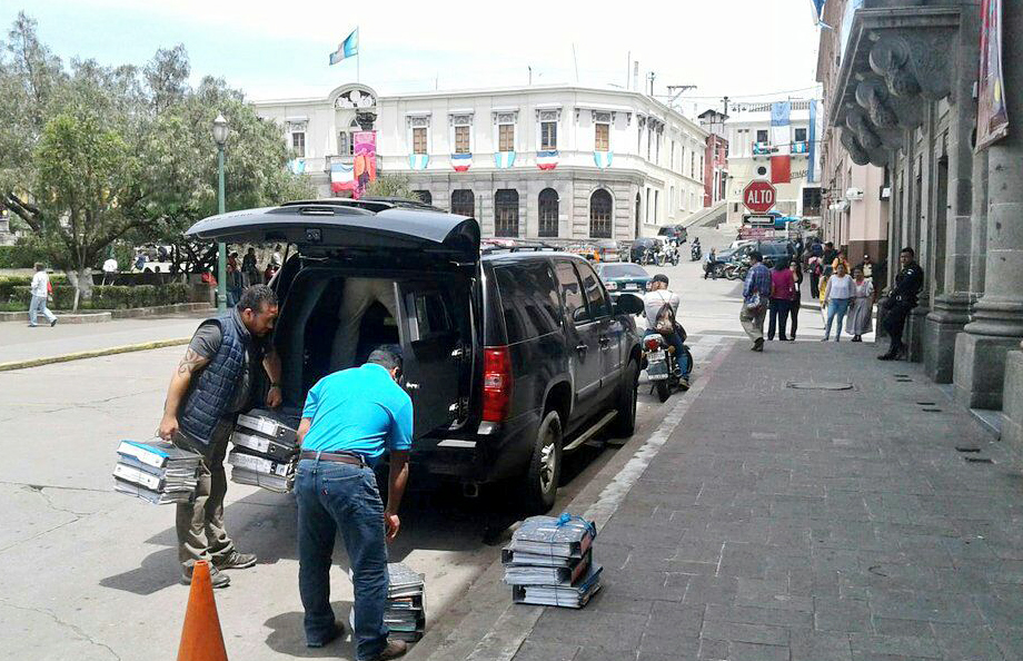 Investigadores de Feci sacan de su vehículo los expedientes secuestrados para su devolución a las autoridades de la comuna de Quetzaltenango. (Foto Prensa Libre: Carlos Ventura)
