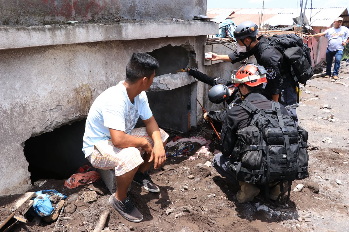 Socorristas junto con un sobreviviente buscan restos de fallecidos en una vivienda. (Foto Prensa Libre: Enrique Paredes)