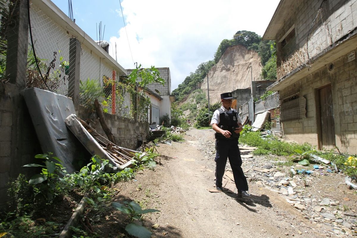 Un policía vigila el área deshabitada en El Cambray 2, considerada de alto riesgo. (Foto Prensa Libre: Érick Ávila)
