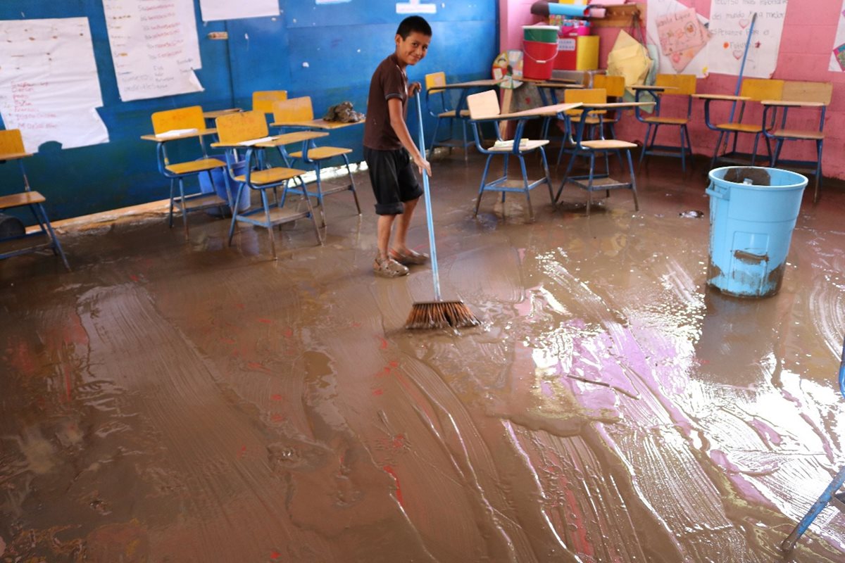 Un estudiante ayuda a los maestros a limpiar uno de los salones de clases de la Escuela San Antonio Chiquito.(Foto Prensa Libre: Héctor Cordero)