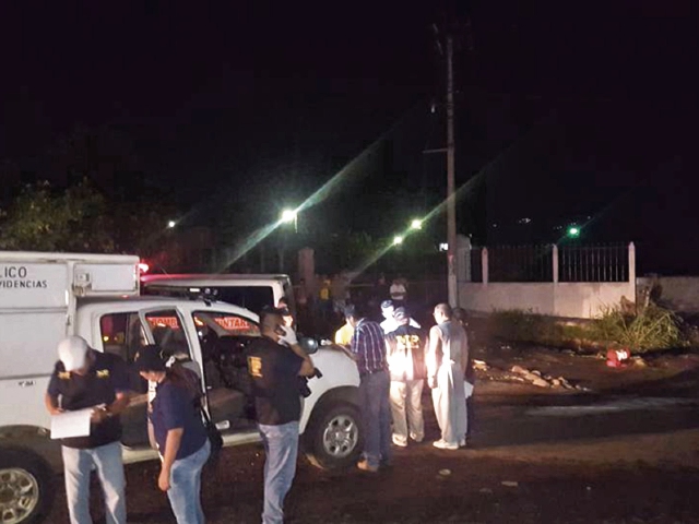 Peritos del Ministerio Público, en lugar donde volcó el bus de Transportes Monja, luego de un ataque armado, en San Antonio Suchitepéquez. (Foto Prensa Libre: Cortesía)