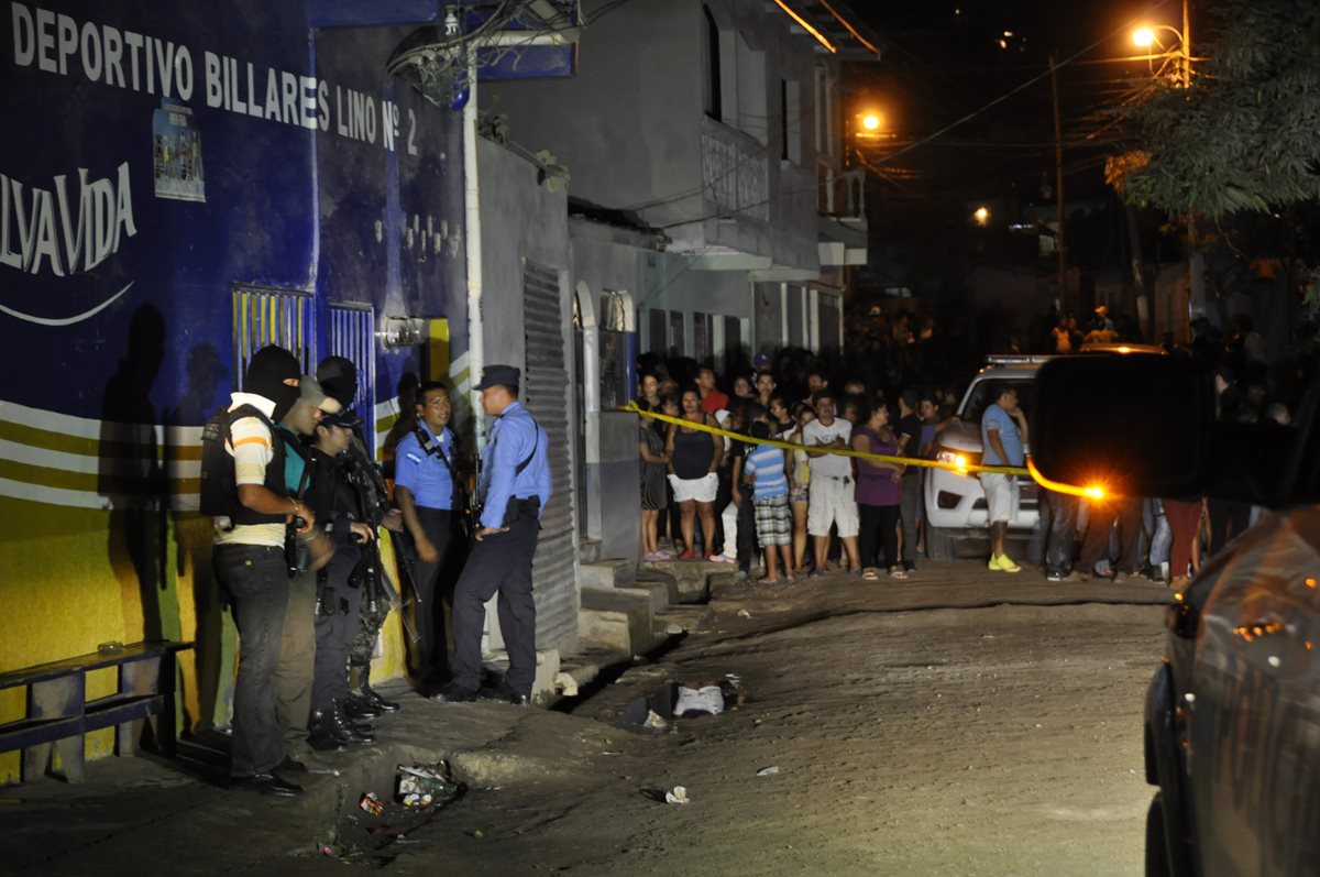 Peritos recaban evidencias en las afueras del lugar donde ocurrió la masacre. (Foto Prensa Libre: AFP).