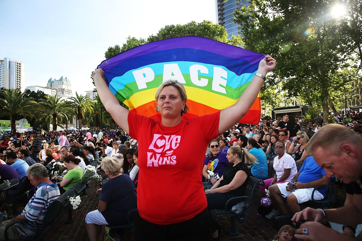 Una activista sostiene una bandera gay durante una muestra de solidaridad por la masacre en Orlando. (Foto Prensa Libre: AFP).