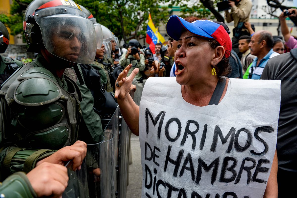 Una mujer grita consignas contra las fuerzas de seguridad que reprimen marchas callejeras contra Maduro en Caracas, Venezuela. (Foto Prensa Libre: AFP).