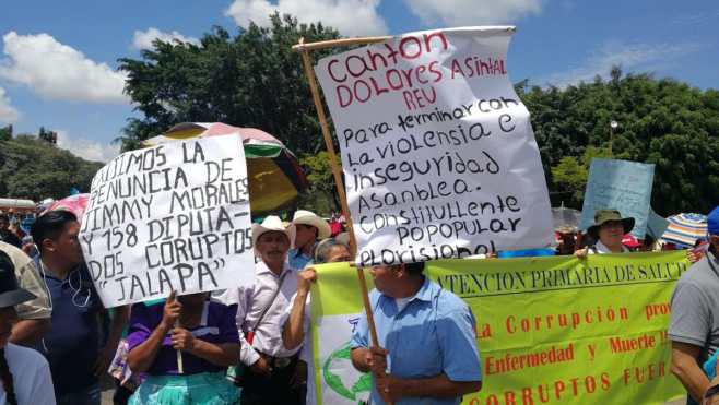 Manifestantes en la Plaza de la Constitución muestran pancartas en rechazo a la corrupción.