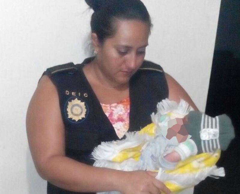 Investigadora de la PNC auxilia al menor rescatado en Chiquimula. (Foto Prensa Libre: PNC).