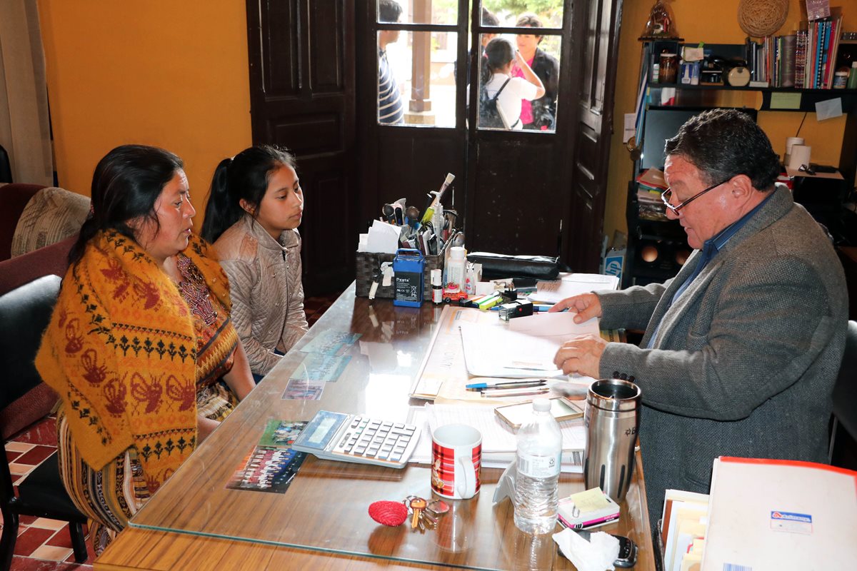 Julio Solís Escobar, director del Ifebo, recibe papelería de una estudiante para inscripción. (Foto Prensa Libre: Carlos Ventura)