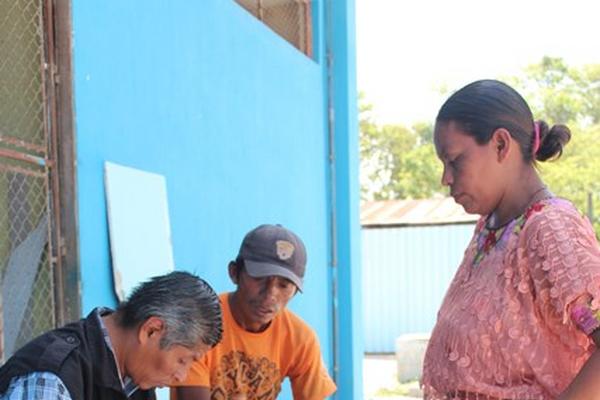 Un investigador del Ministerio Público habla con los padres de  adolescente que murió tras haber sido ultrajada. (Foto Prensa Libre:  Rigoberto Escobar)