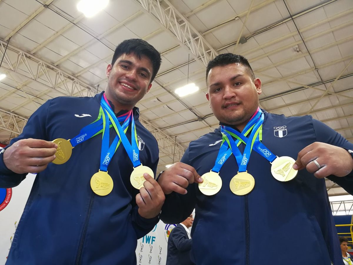 Gilberto Lemus, en 105 kilogramos, y Luis Hoil en +105 kilogramos, muestran los oros conseguidos en las pesas. (Foto Prensa Libre: Carlos Vicente)