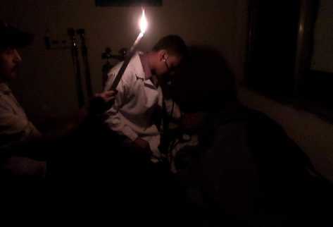 Médicos del Centro de Atención Permanente de Jacaltenango, Huehuetenango, examinan a un paciente con ayuda de una candela.