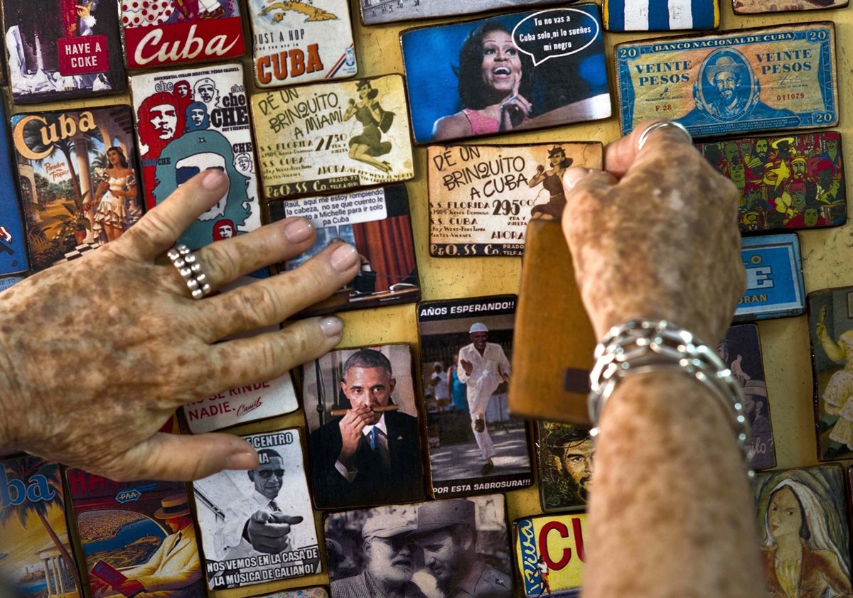 Una cubana muestra varios artículos promocionales a la venta alusivos a la visita de Obama. (Foto Prensa Libre: AP).