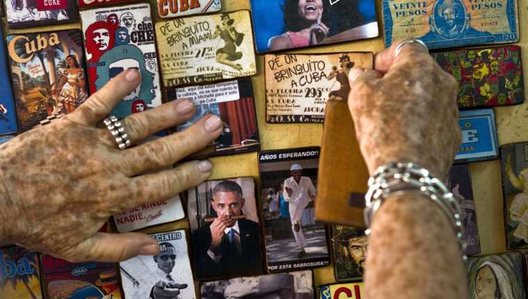 Una cubana muestra varios artículos promocionales a la venta alusivos a la visita de Obama. (Foto Prensa Libre: AP).